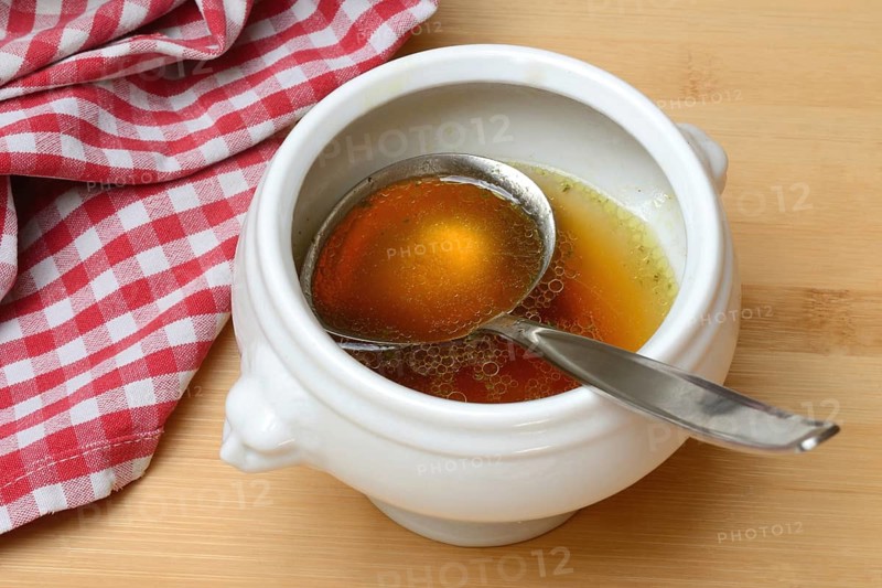 Bouillon, beef broth with ladle in bowl