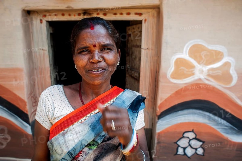 Woman from the Santhal tribe, house with Sohraï art decoration (Hazaribagh district, Jharkhand, India) . The Sohraï and Khovar art are art forms practised by the rural low caste and tribal women in the Hazaribagh district. Every october-november, they paint their house mud walls to welcome the harvest and celebrate the cattle. These paintings depict animals and plants of the surroundings in a simple way