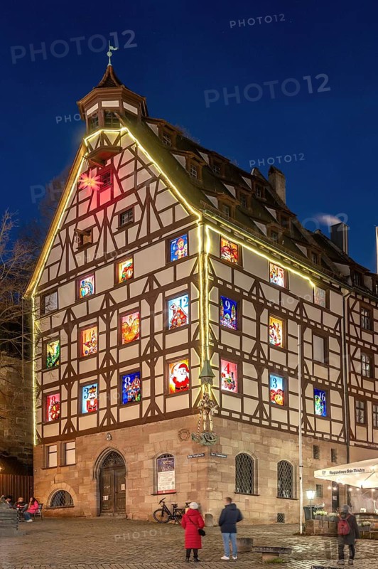 Pilatushaus, built in 1489, a historic town house with an Advent calendar on 18 December 2024 at dusk, the Imperial Castle on the right, Tiergärtnertorplatz, Nuremberg, Central Franconia, Bavaria, Germany