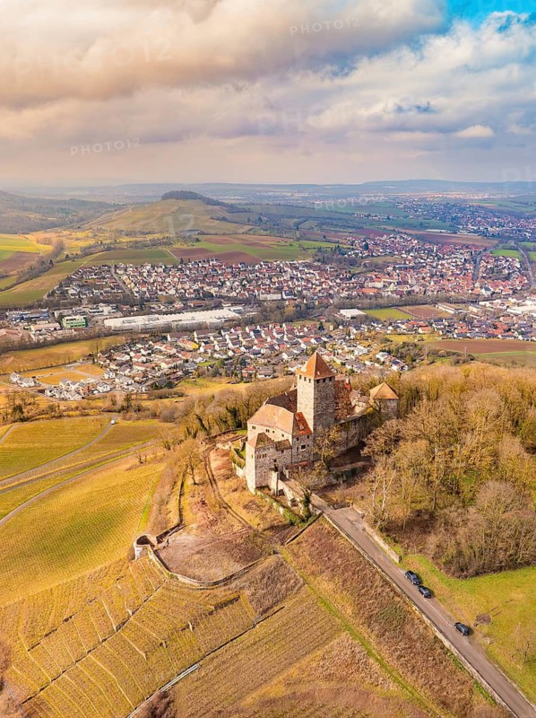 A fascinating castle overlooks extensive fields and a village, nestled in a hilly landscape, Lichtenberg Castle, Oberstenfeld, Germany