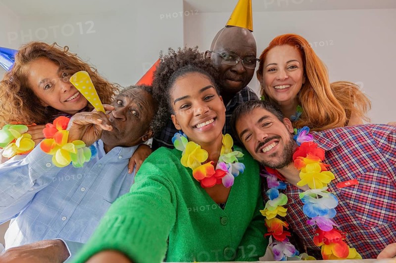 A joyful group of friends celebrates a birthday with colorful decorations, wearing party hats and leis, capturing the essence of togetherness and happiness