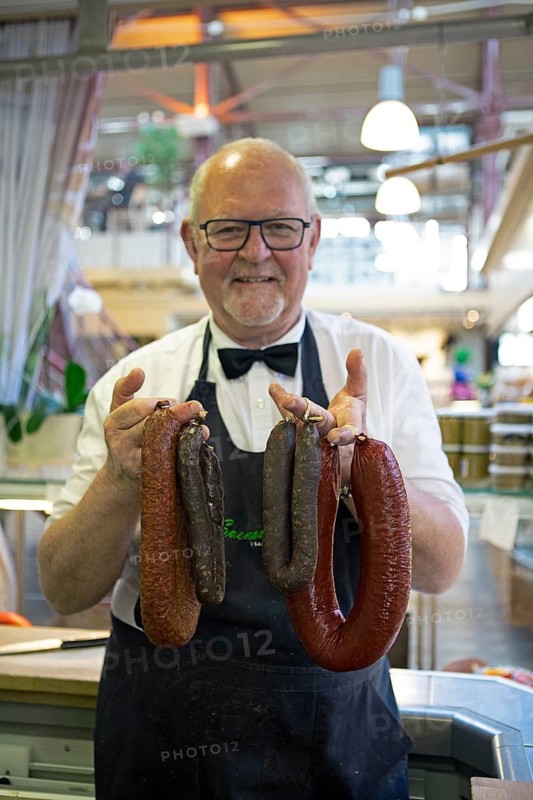 Swedish man, 70 years old, showing Swedish sausages from Helsingborg, Saluhallen, Gothenburg, Västra Götalands län, Sweden