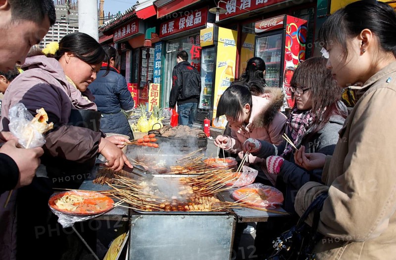 Beijing, CHN, 20.02.09 - Chinese eat meat skewers at a grill stand, CHINA