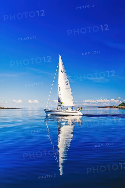 German sailboat with beautiful water reflections on a calm day in the sea archipelago on a sunny summer day, Bohuslän, Sweden