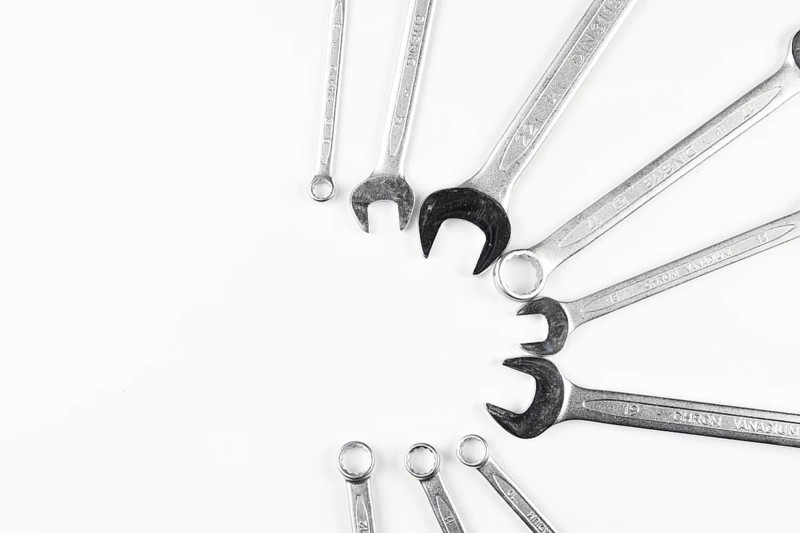 Several wrenches are arranged in a circle on a white background