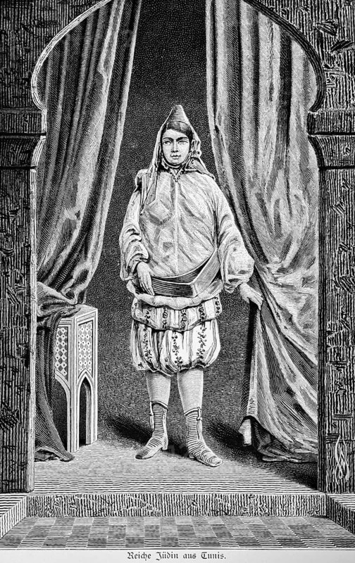Rich Jewish woman from Tunis stands under a round arch, living room, oriental clothing, bloomers, pointed hat, wide belt, high lace-up shoes, curtain, side table, mosaic floor, historical illustration, Tunisia, 19th century woman