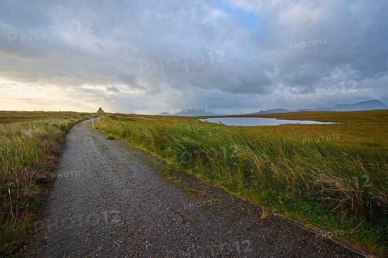 A trail leads along a lake through a flat landscape under a cloudy sky, Moine House, Moine Track, Lairg, Scotland, United Kingdom, Great Britain