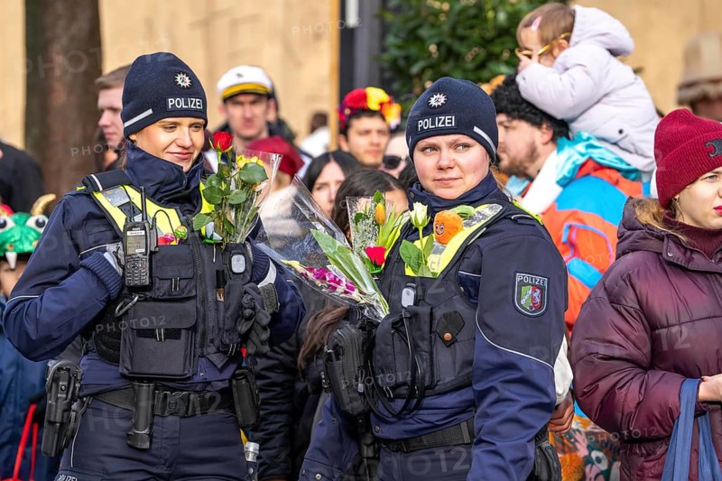 Rose Monday procession in Düsseldorf, emergency services, secure, accompany the move, policewoman with bouquets of flowers, Strüsschen, in some cases heavy rain, North Rhine-Westphalia, Germany