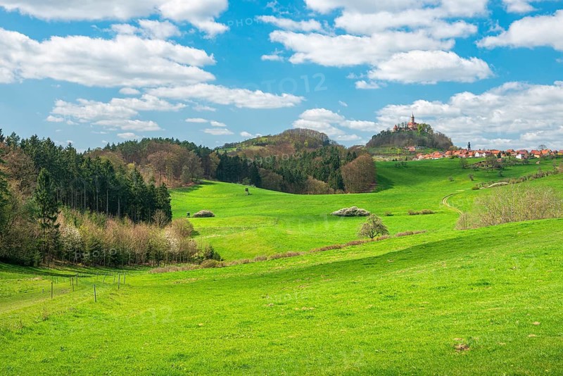 View of hilly landscape with the village of Seitenroda, the Leuchtenburg, green meadows and forests in spring, near Kahla, Thuringia, Germany