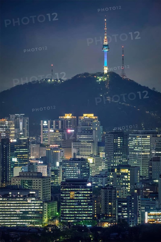 Seoul downtown cityscape illuminated with lights and Namsan Seoul Tower in the evening view from Inwang mountain. Seoul, South Korea