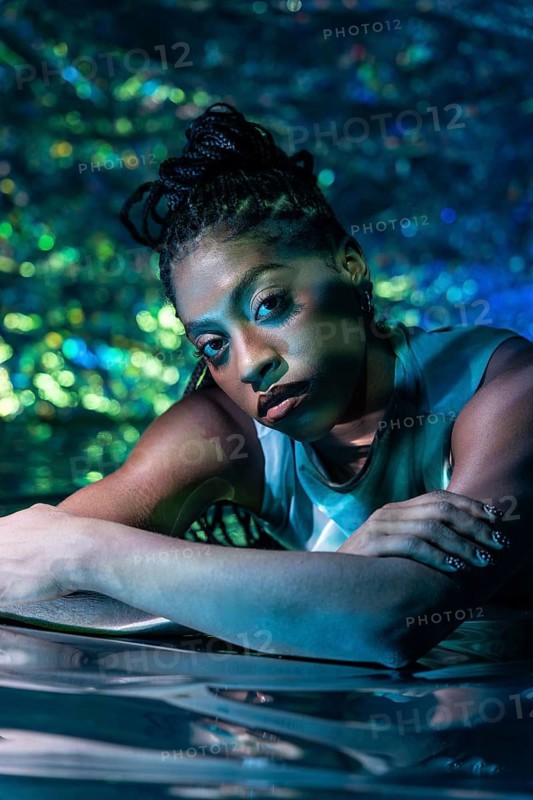 A futuristic African young woman is portrayed in a vibrant, digital environment, symbolizing the immersive experience of the metaverse, blending reality and virtual elements