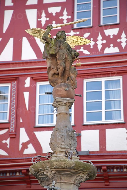 Justice with wing, beam scale and sword as a symbol of justice, stone sculpture, half-timbered, market fountain, market square, Bernkastel-Kues, Middle Moselle, Rhineland-Palatinate, Germany
