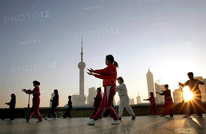 Shanghai, CHN, 16.11.2004 - Tai Chi at sunrise on the Bund in front of the Pudong skyline with Oriental Pearl Tower in Shanghai, Shanghai, China