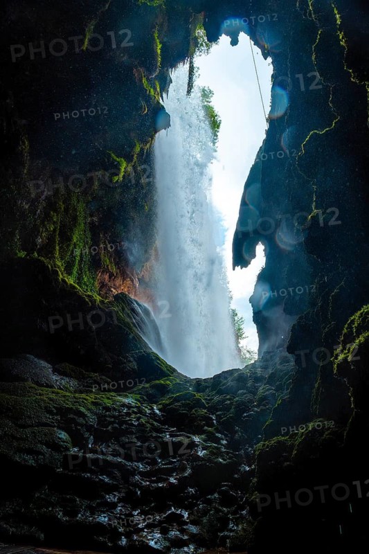 Inside the waterfall in the Iris Grotto at the Cola de Caballo Waterfall in the Monasterio de Piedra Natural Park, Aragon