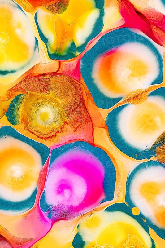 An abstract image featuring vibrant swirls of ink in a variety of colors including pink, yellow, orange, blue, and green on a glossy background. The mix creates a visually rich texture that resembles fluid motion