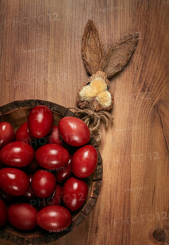Painted eggs in a wooden bowl, red, painted madder dye, powder from the roots of endro, with onion husks, top view, Easter, Georgia