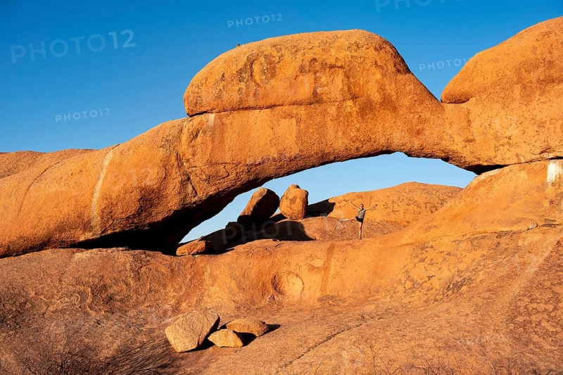 Morning, woman standing in rock arch, Pontok Mountains, Große Spitzkoppe, Spitzkoppe, Große Spitzkuppe Nature Reserve, Namibia