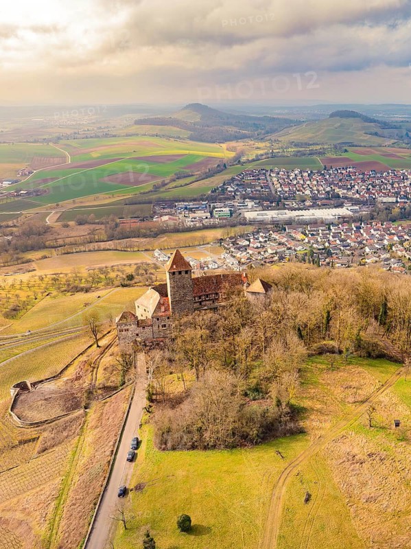 Aerial view of a castle with surrounding fields and a nearby village, embedded in a hilly landscape, Lichtenberg Castle, Oberstenfeld, Germany