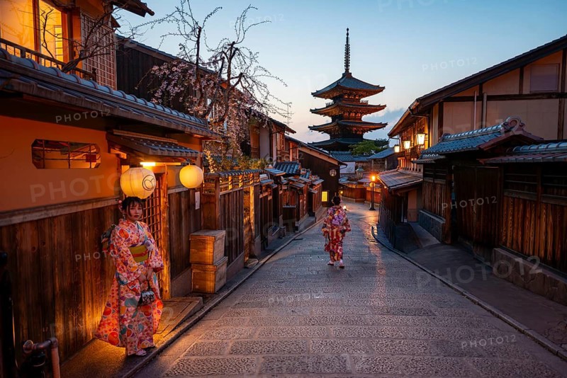 Japanese woman in kimono in an alley, Yasaka dori historic alleyway in the old town with traditional Japanese houses, five-story Yasaka pagoda of the Buddhist Hokanji temple, evening mood, Kyoto, Japan