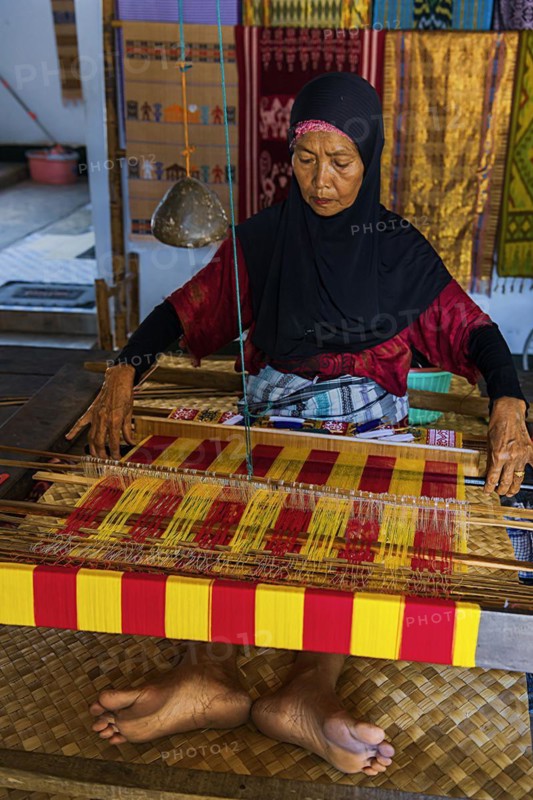 Traditional weaver, weaving, woman's work, working conditions, loom, textile, woman, trade, bazaar, authentic, fabric, fabric pattern, craft, handicraft, Asian, indigenous, tradition, traditional, marketplace, travel, tourism, culture, poverty, presentation, lifestyle, person, Muslim, Islam, Sasak, indigenous, indigenous people, cultural heritage, silk weaving, Sade village, Lombok, Indonesia