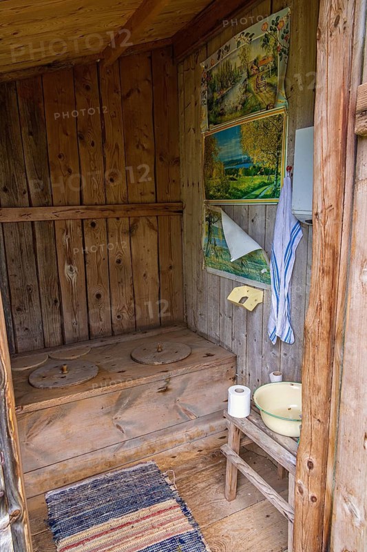Interior of an old idyllic wooden outhouse with space for two in the countryside, Sweden