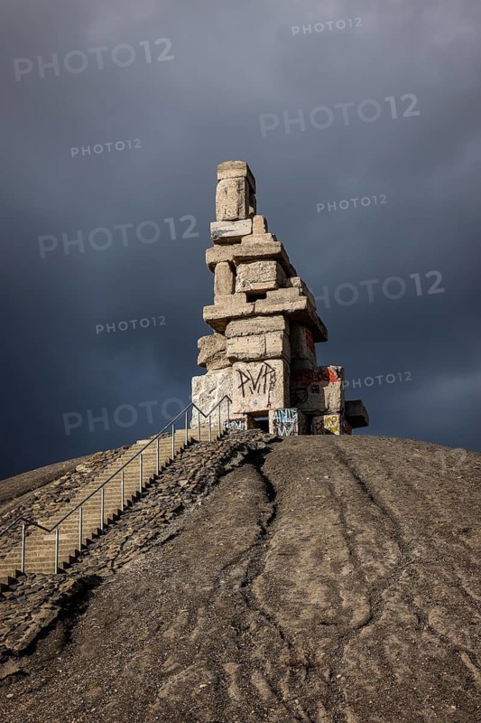 Gelsenkirchen, North Rhine-Westphalia, Germany - Rheinelbe slagheap with artwork Himmelstreppe made of old concrete parts of the former Rheinelbe colliery in front of a dark sky, artist Herman Prigann
