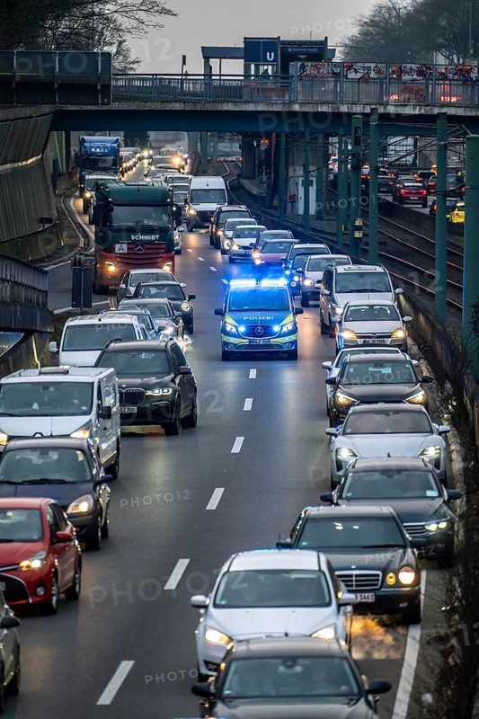 Traffic jam on the A40 motorway, emergency lane, vehicles on the left and right, police patrol car with flashing blue lights and siren, Essen, North Rhine-Westphalia, Germany