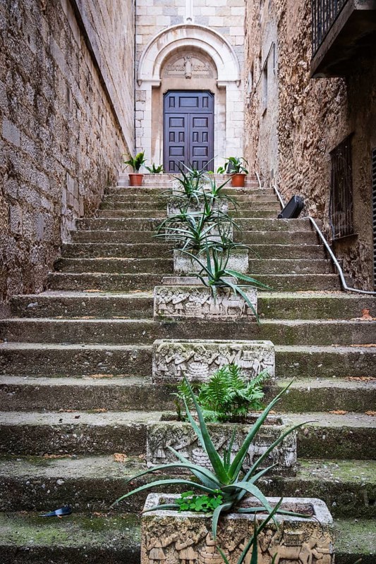 Stone flower pot on a staircase to a church in Figueras, Spain