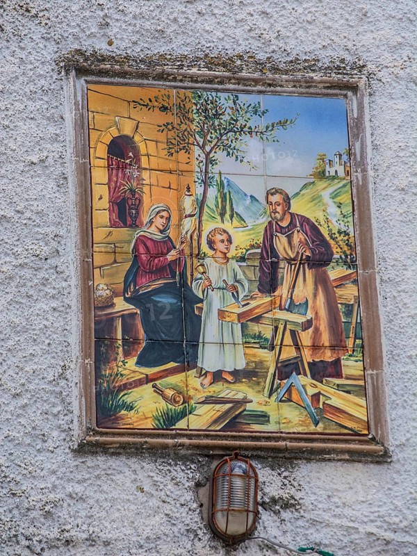 Mural depicting the Holy Family with Jesus as a child, Joseph as a carpenter and Mary spinning sewing thread in Bernalda, Basilicata region, Italy, Southern Europe