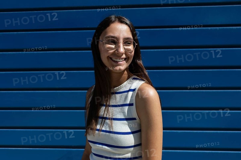A woman enjoys the urban lifestyle, embodying freedom and vitality in the city. Her smile reflects a joyful embrace of the outdoor urban experience, blending style and modernity