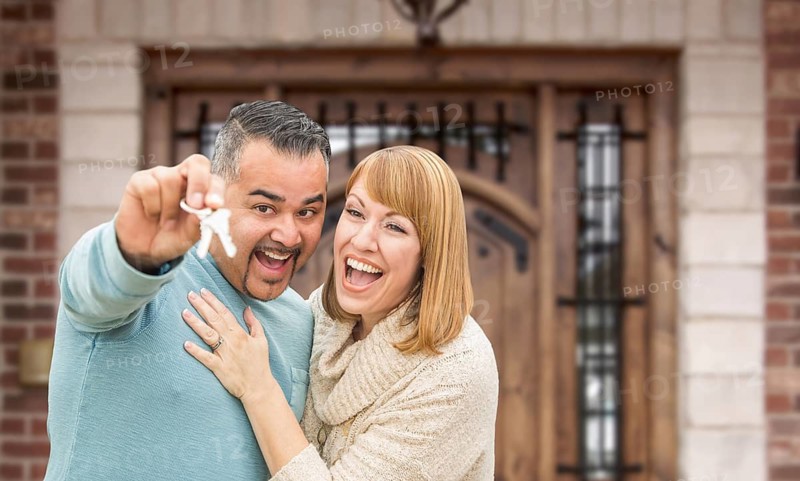 Mixed Race Couple In Front of Front Door of New House Holding Keys