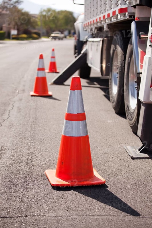 Several Orange Hazard Cones and Utility Truck in Street