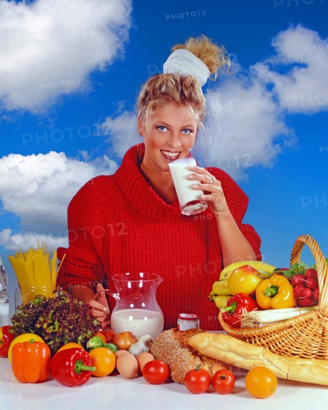 Young blonde woman eating a yoghurt for breakfast, Studio