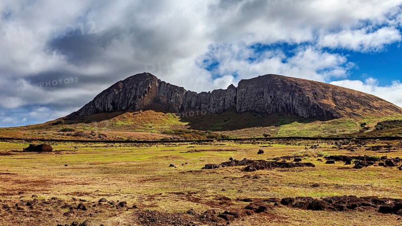 Distinctive rock formation rises under clouds in a vast landscape, the landscape of Easter Island in the Pacific Ocean