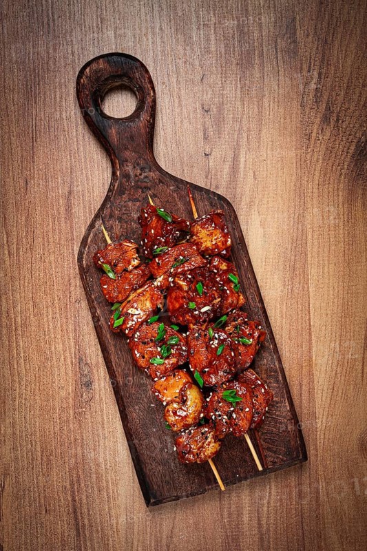 Yakitori chicken kebab, on skewers, with green onions and sesame seeds, top view, without people