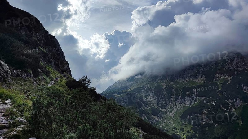 Dramatic cloud formations over high mountains and a steep trail, Zakopane, hiking in the High Tatras National Park, Carpathian Mountains, Poland