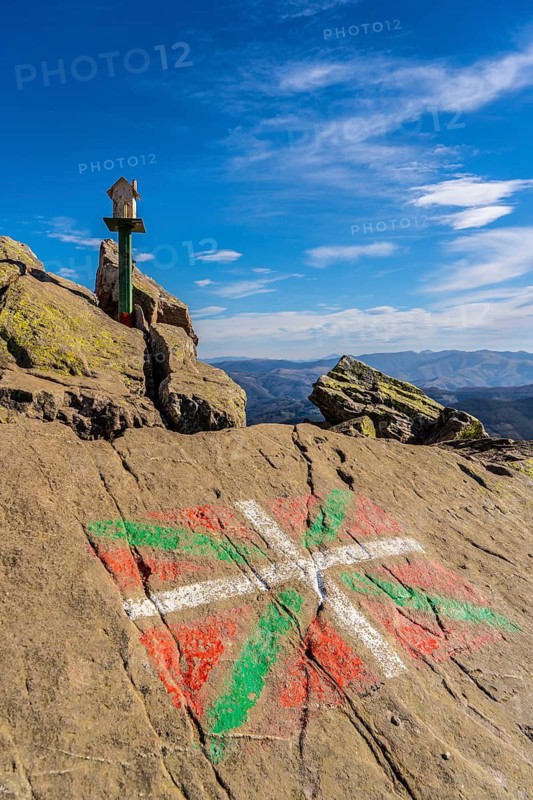 The flag of the Basque country and a figure of a house above Mount Adarra in Guipuzcoa one winter morning