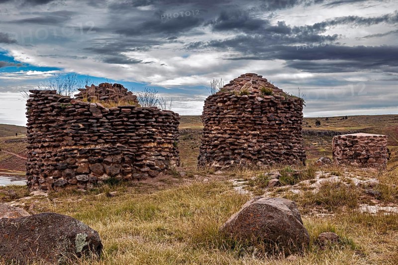 Two old stone towers on a grassy area, The Chullpas of Sillustani near Puno in Peru