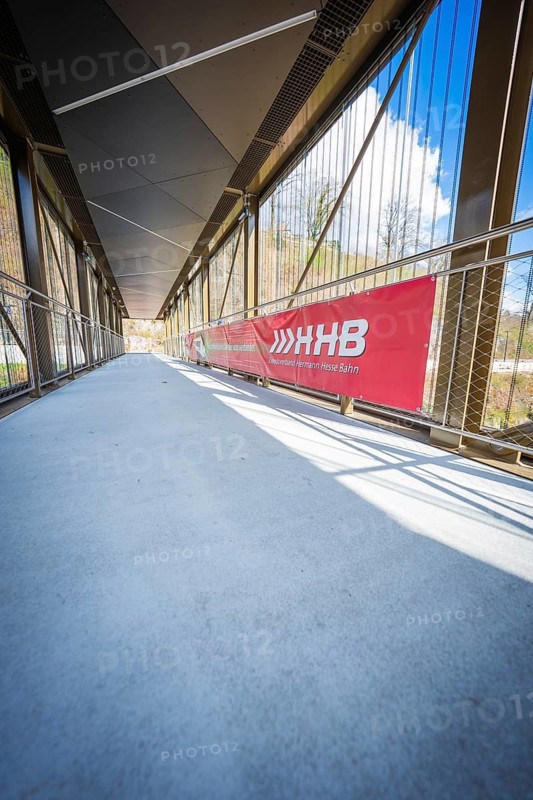 Modern footbridge with glass and metal structures on a sunny day, Hermann Hesse Bahn, ZOB, Calw, Germany