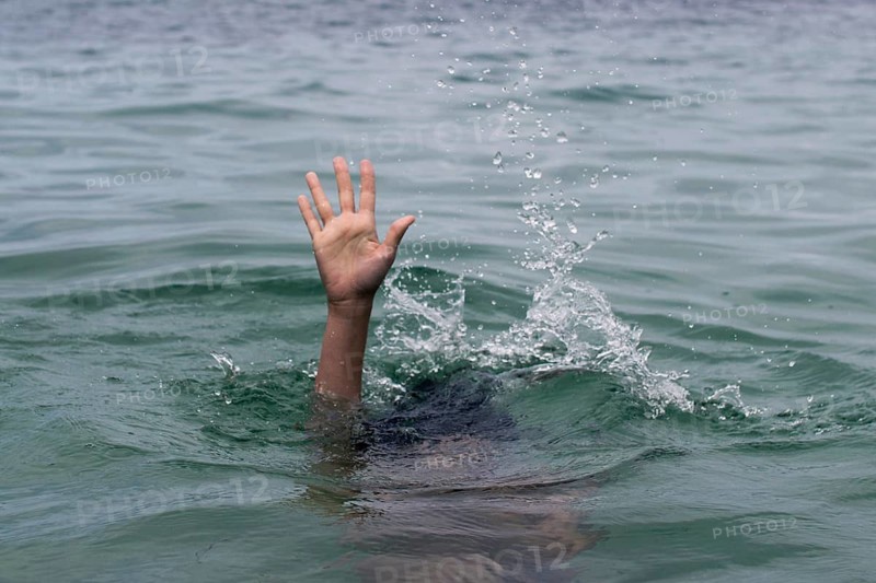 A hand emerges from turbulent water, reaching upward in a desperate plea for help. This dramatic scene captures urgency and struggle in the midst of a challenging situation