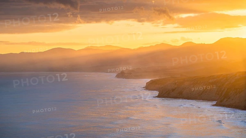 Wairarapa coast at sunset. Sea, mountains, backlight. Castlepoint, Wairarapa Coast, Wellington Region, North Island, New Zealand