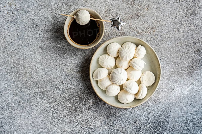 Indulge in homemade vanilla mini zephyr-marshmallows filled with rose jam, perfectly paired with a refreshing coffee liqueur drink served for a delightful treat
