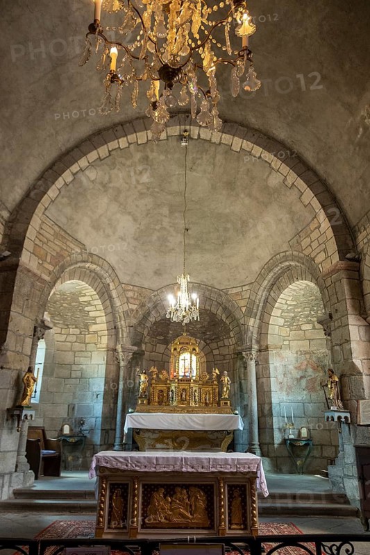 Auzon village. Interior of Saint Laurent Collegiate church featuring stone arches and an ornate altar, Haute Loire, Auvergne Rhone Alpes, France