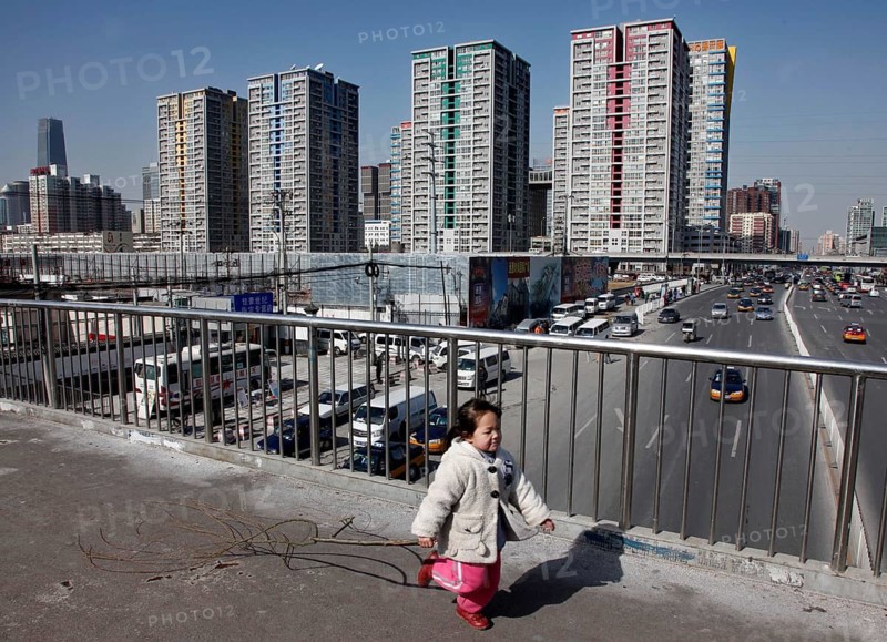 Beijing, CHN, 20.02.09 - A little girl plays on a footbridge on a busy street in Beijing, CHINA