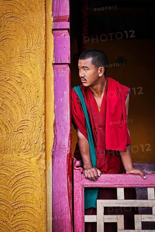 THIKSEY, INDIA, SEPTEMBER 13, 2012: Young Buddhist monk standing in doorway of of Thiksey gompa, Ladakh, India