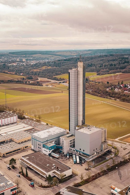 The picture shows a tall industrial building in an agricultural area under cloudy sky, Schapfenmühle, Jungingen, Ulm, Germany
