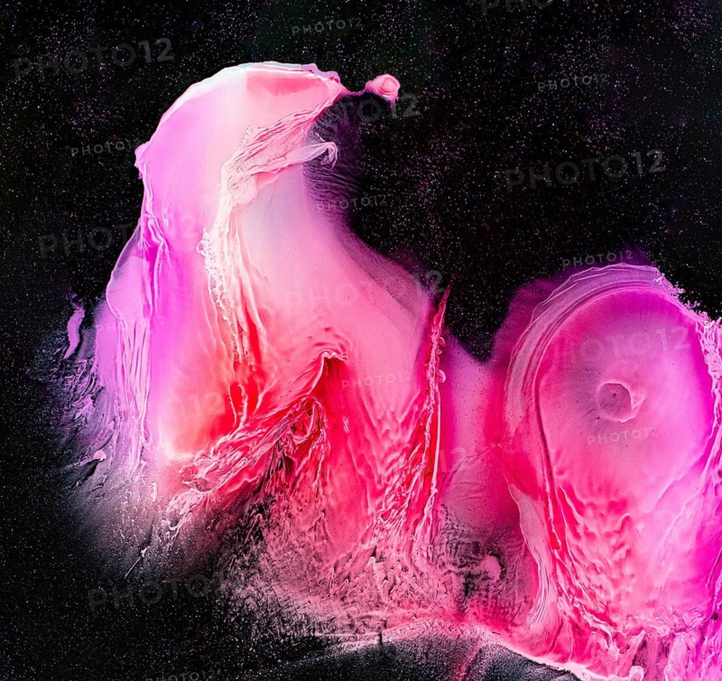 This vivid abstract artwork showcases swirling pink and red hues against a rich black backdrop, creating a galactic and ethereal effect. Perfect for creative projects