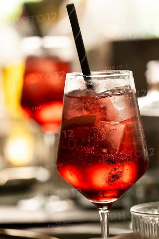 Cocktail in a glass with ice cube cubes against the light