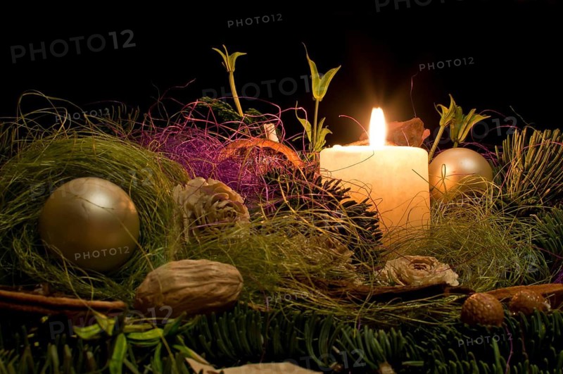 Christmas decoration with a burning candle on a black background in Poland