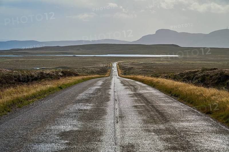 Straight road runs through open landscape with mountains in the background under partly cloudy sky, Tongue, Lairg, Scotland, United Kingdom, Great Britain